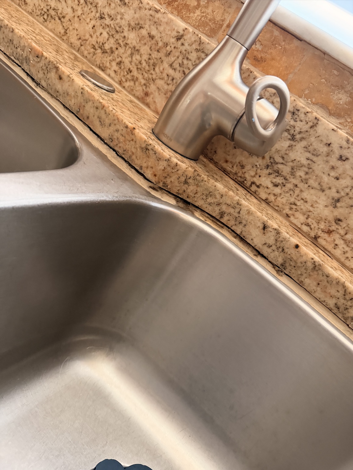 Before kitchen sink recaulking in Tampa by Flourish Home Services