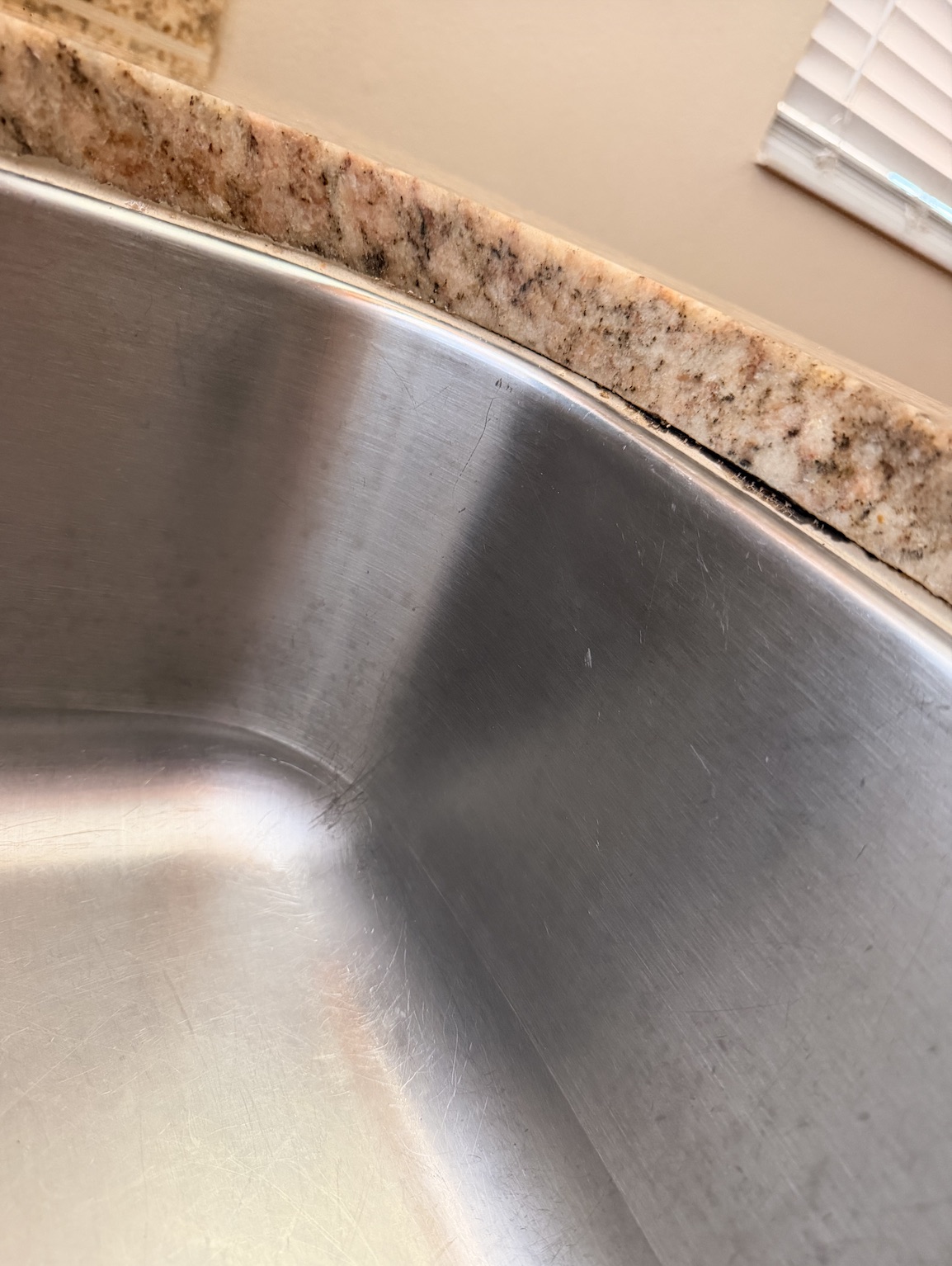 Before kitchen sink caulk gap and cleanup by Flourish Home Services